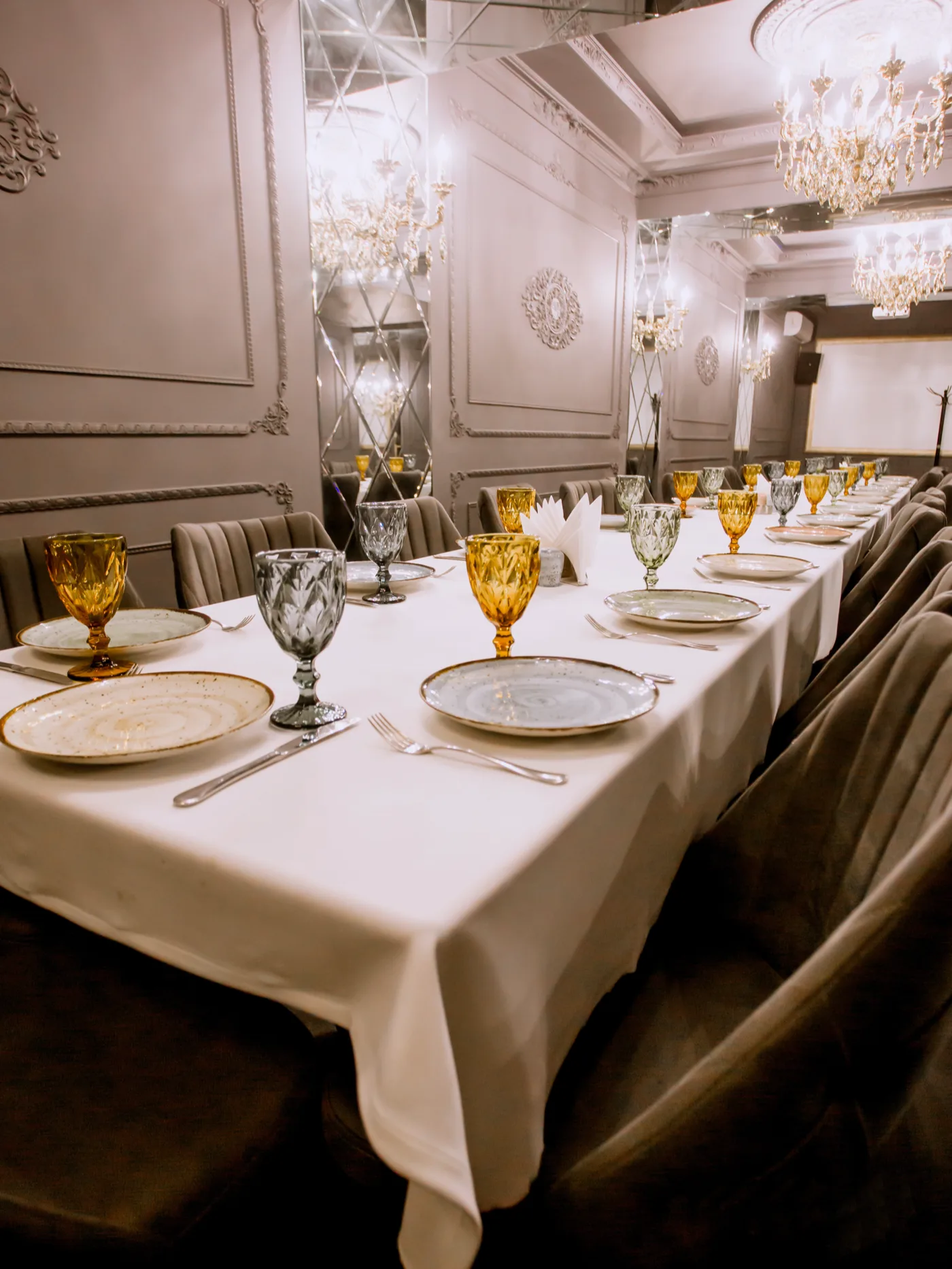 Festlich gedeckte lange Tafel mit Gläsern und Tellern