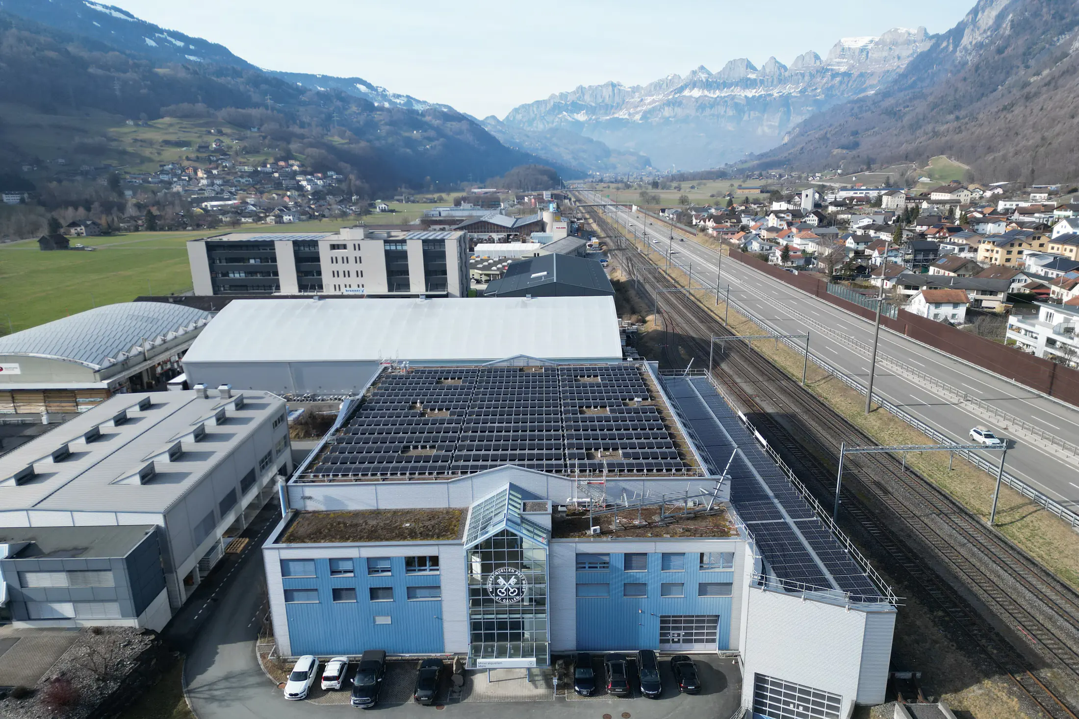 Photovoltaikanlage auf dem Dach der Mineralquellen Mels vor der Melser Bergkulisse